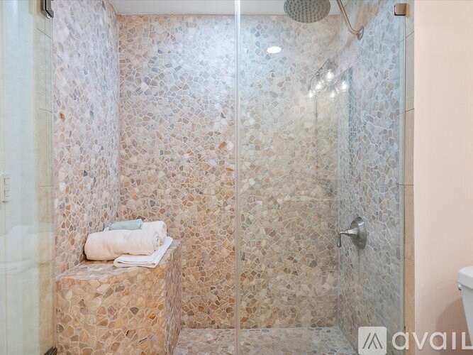 A bathroom with a shower and a bench.