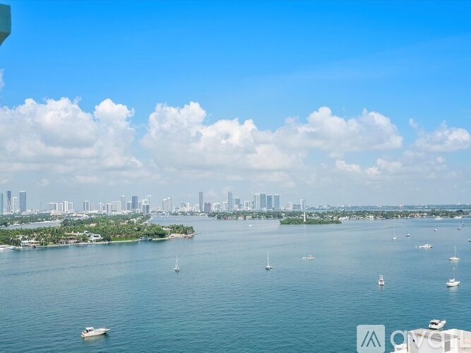 A view of a city skyline from a high vantage point with boats in the water.