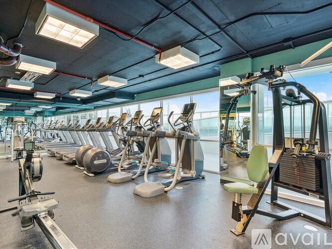 A gym with various exercise machines and a green chair.