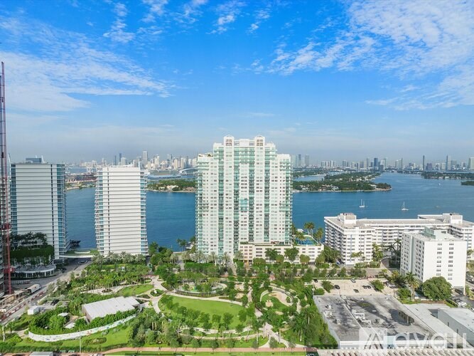 A view of a city with a large body of water and a tall building in the foreground.