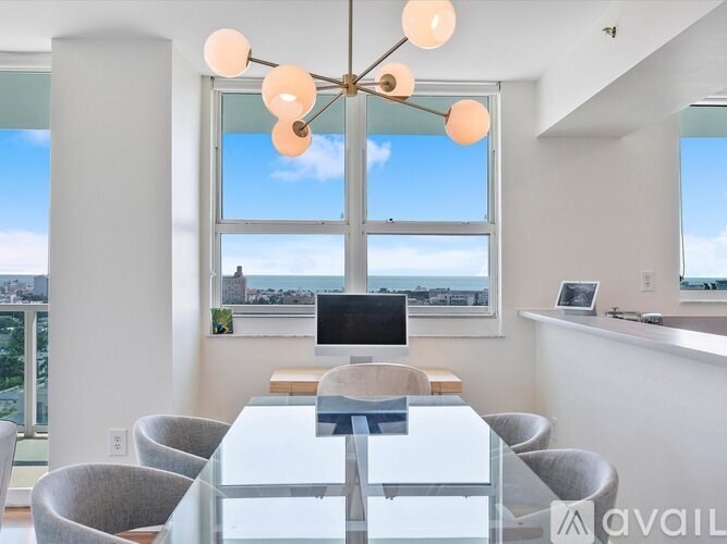 A modern dining room with a glass table and chairs.