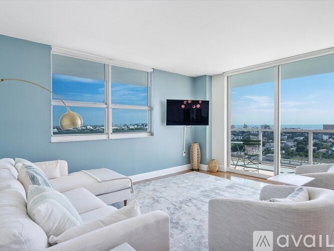 A living room with a large window overlooking the city.
