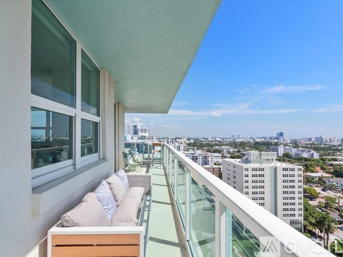 A balcony with a couch and a view of the city.