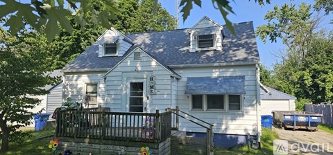 A white house with a black gate in front.