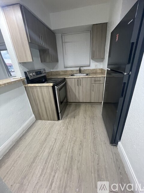 A kitchen with a black fridge and a black oven.