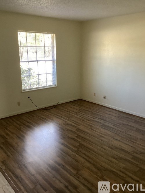 A room with wooden flooring and a window.