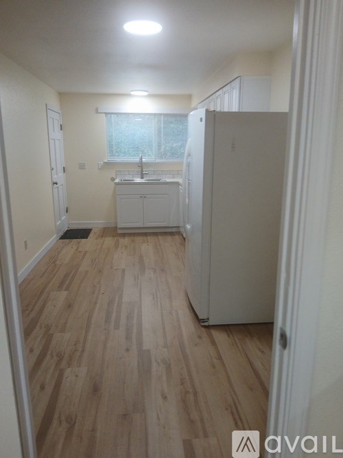 A kitchen with a sink and a refrigerator.