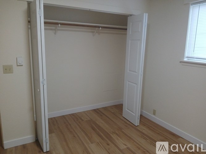 A room with a white door and a window with blinds.