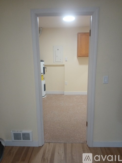 A room with a white door and a brown floor.