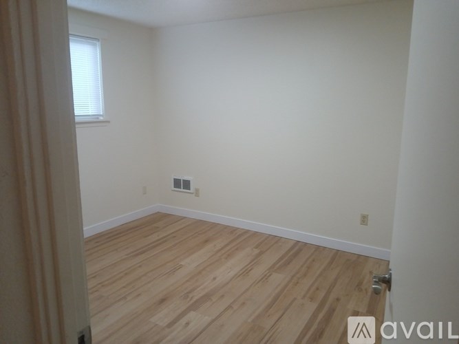 A room with wooden flooring and a window.