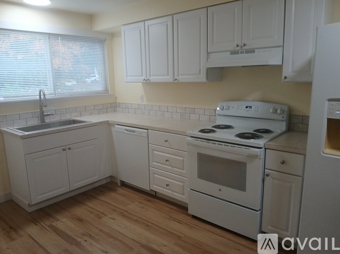 A kitchen with white appliances and cabinets.