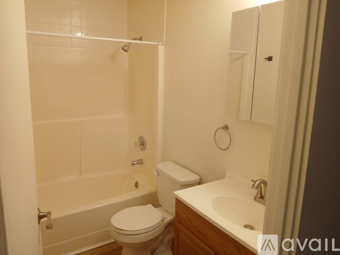 A white toilet sits in a bathroom next to a white sink.