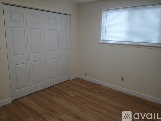 A room with a white door and a window with blinds.