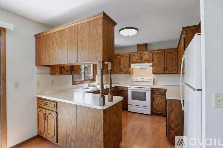A kitchen with wooden cabinets and white appliances.