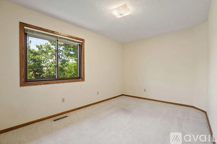 A room with a window and carpeted floor.