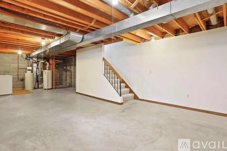 A spacious room with a staircase and a concrete floor.