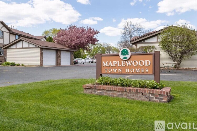 A sign for Maplewood Town Homes is in front of a building.