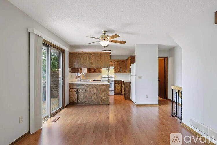 A spacious living room with wooden floors and a ceiling fan.