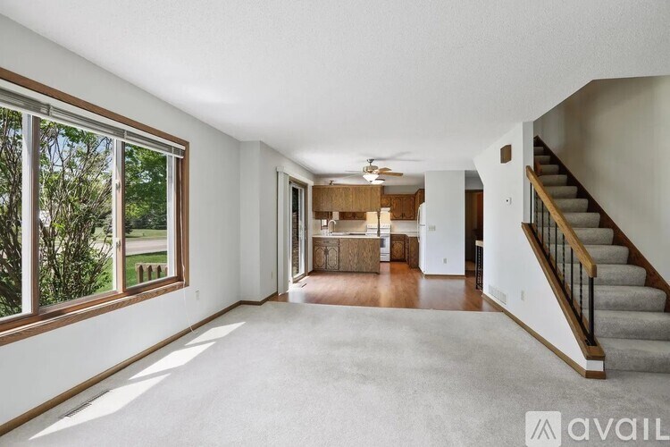 A spacious living room with a staircase leading to the upper floor.