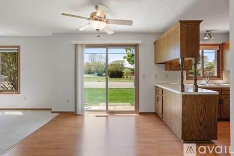 A kitchen with wooden cabinets and a ceiling fan.