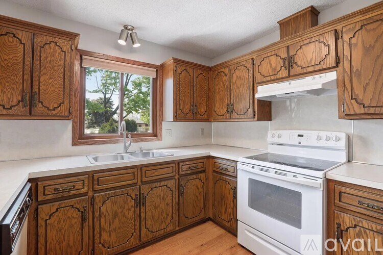 A kitchen with wooden cabinets and a white stove top oven.