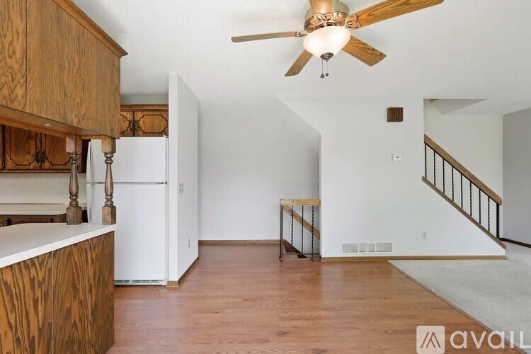 A room with a ceiling fan and a staircase.