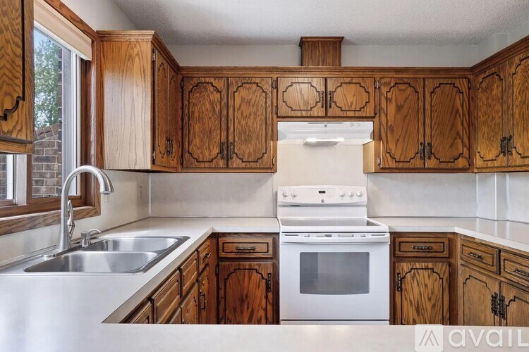 A kitchen with wooden cabinets and a white oven.