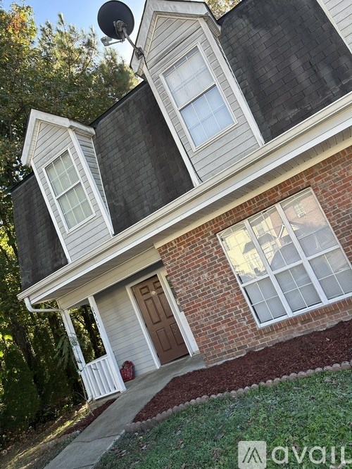 A house with a brown door and a satellite dish on the roof.