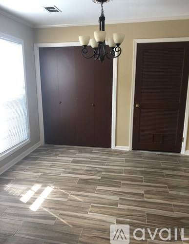 A room with a chandelier and a wooden floor.