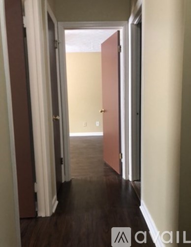 A hallway with a brown door and a white door.