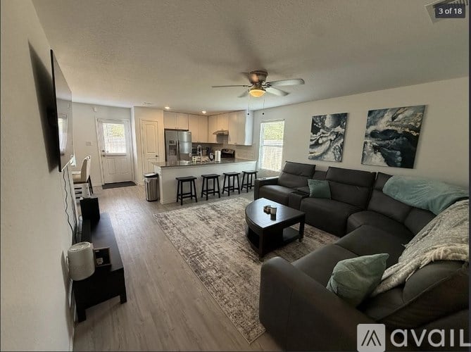 A living room with a couch, a coffee table, and a television.