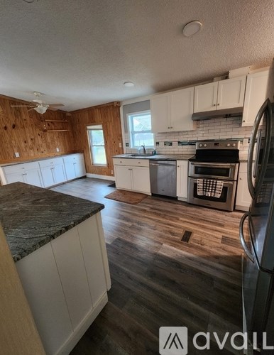 A kitchen with wooden cabinets and a marble countertop.