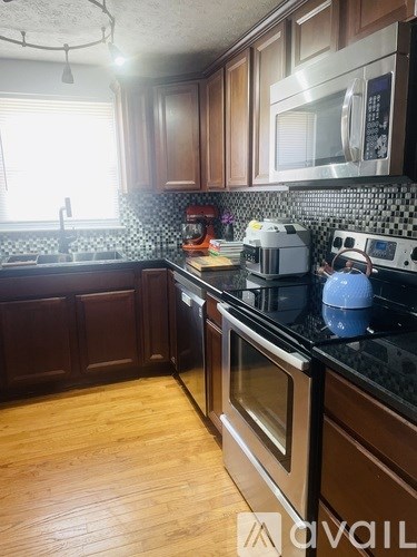 A kitchen with wooden cabinets and black countertops.