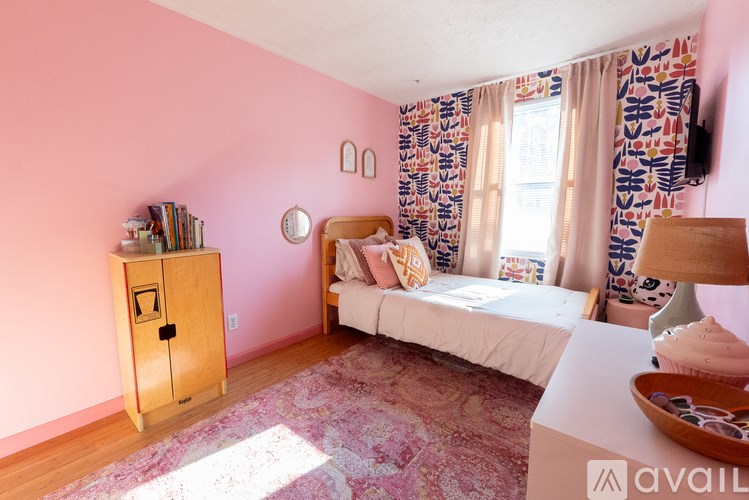 A bedroom with a bed, a cabinet, and a window with curtains.
