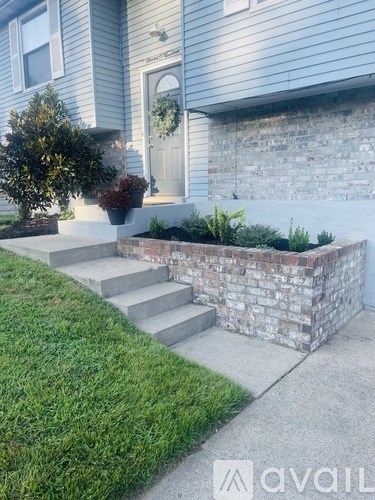 A house with a grey front door and a brick wall.