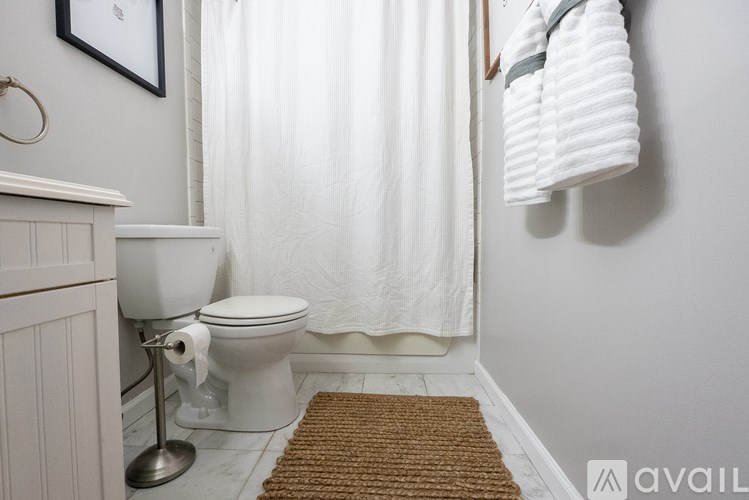 A white toilet with a towel hanging on the wall.