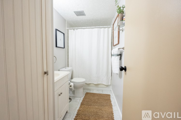 A bathroom with a toilet, sink, and a door.