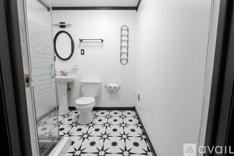 A white toilet and sink in a black and white tiled bathroom.