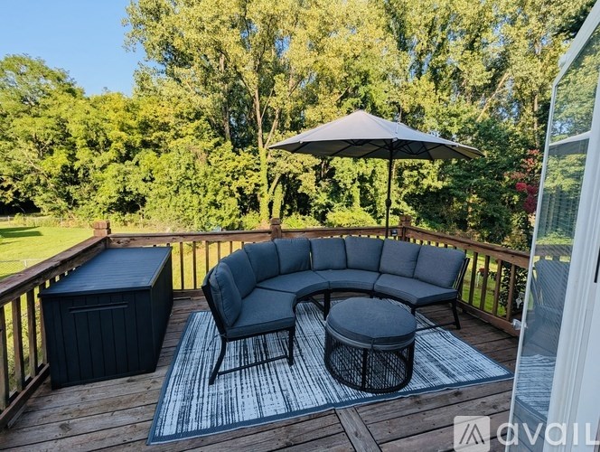A black outdoor furniture set is on a wooden deck.