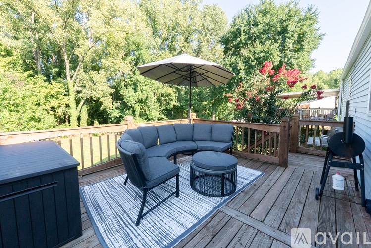 A patio with a grey sofa and a black table.