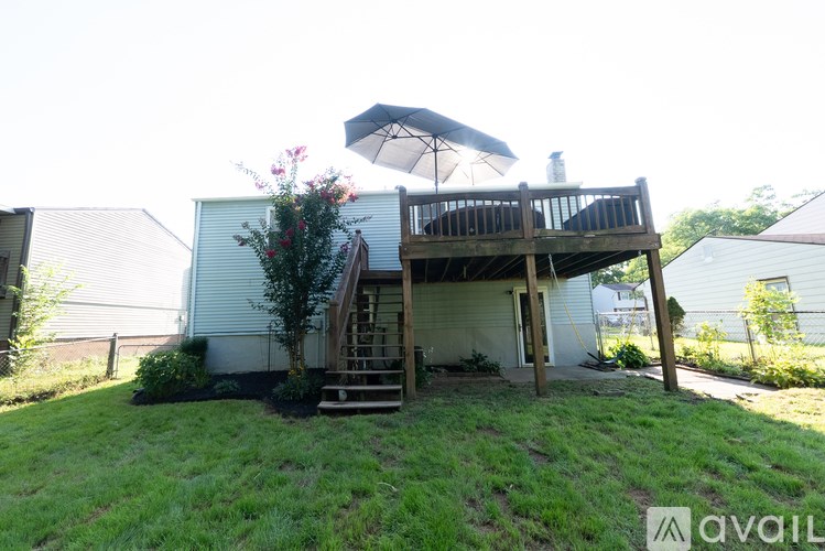 A house with a deck and an umbrella is for sale.