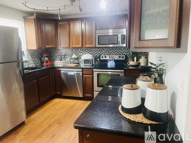 A kitchen with wooden cabinets and a black countertop.