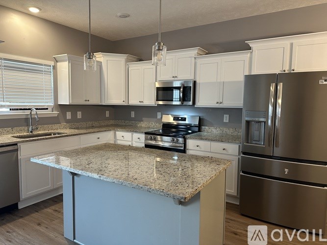 A kitchen with granite countertops and stainless steel appliances.