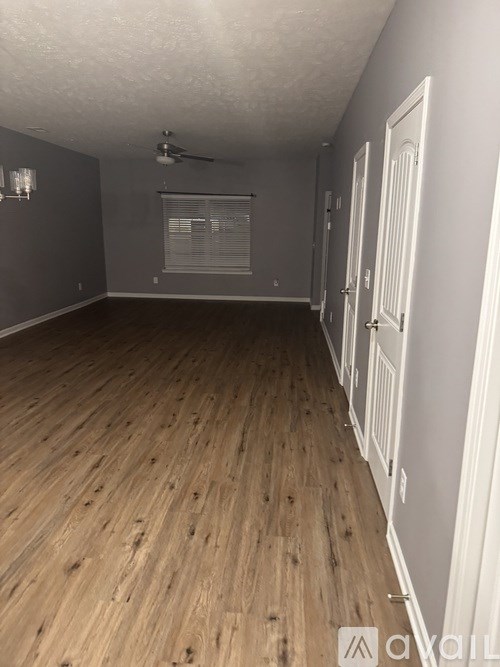 A room with wooden flooring and white walls.