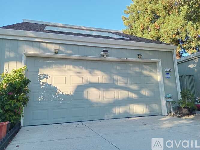 A house with a large garage door and a small window above it.
