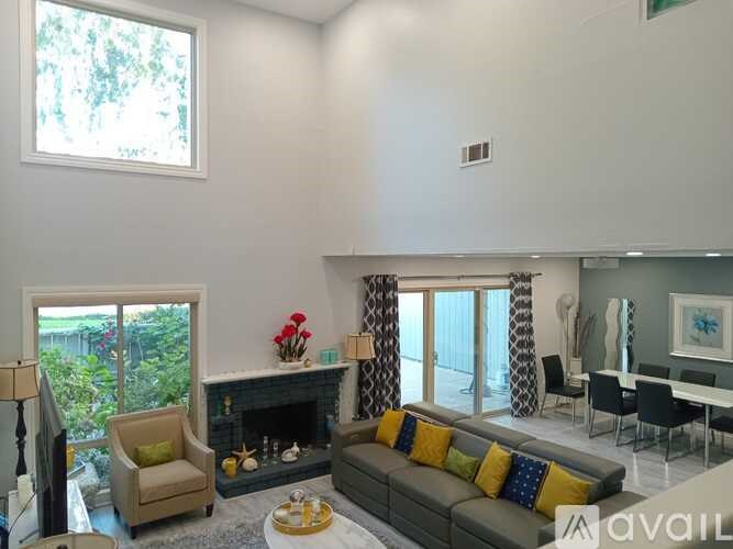 A living room with a grey couch and a fireplace.