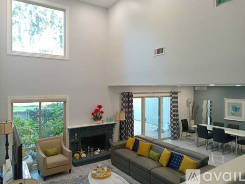 A living room with a grey couch and a fireplace.