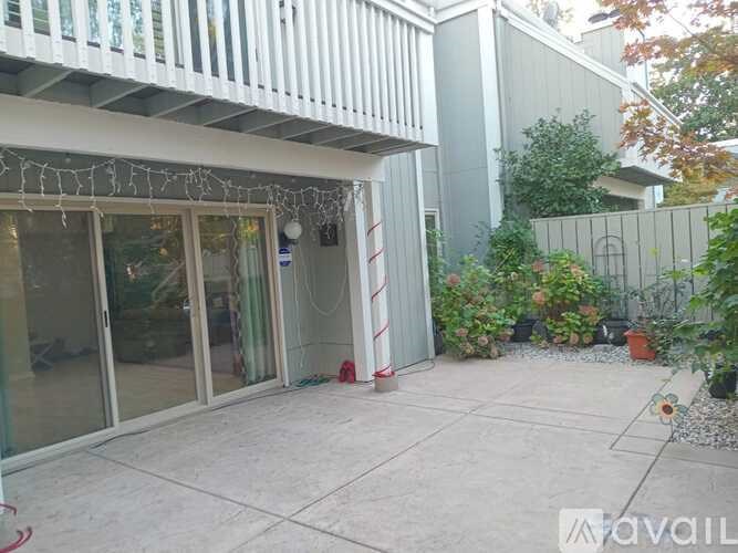 A patio area with a white railing and glass doors.