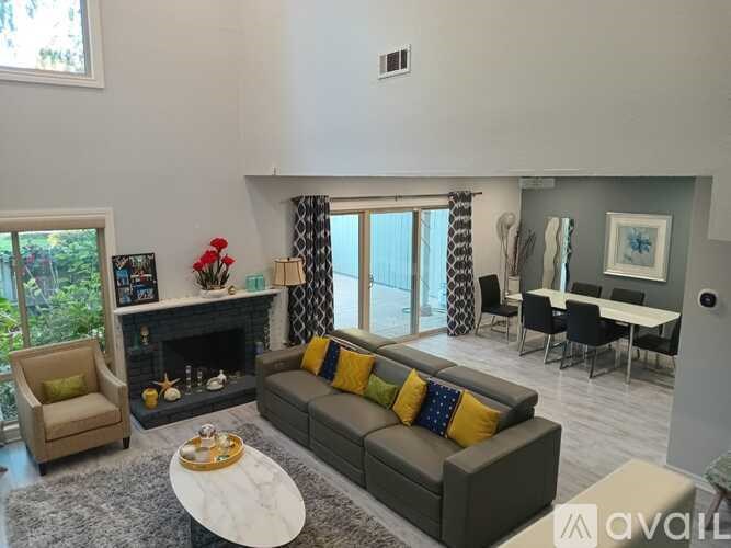 A living room with a grey couch and a fireplace.