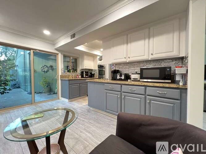 A kitchen with a glass table and a couch.